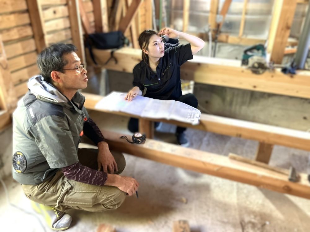 現場での様子（女性設計士と大工さんによる打合せ）