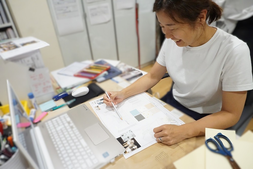 事務所にてプレゼンボード作成する女性設計士
